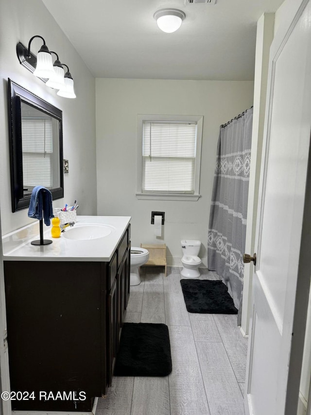 bathroom featuring tile flooring, toilet, and vanity with extensive cabinet space