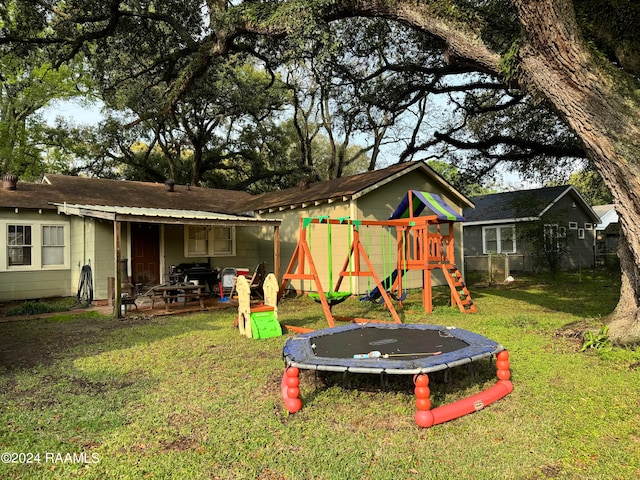 view of yard featuring a trampoline, a patio area, and a playground