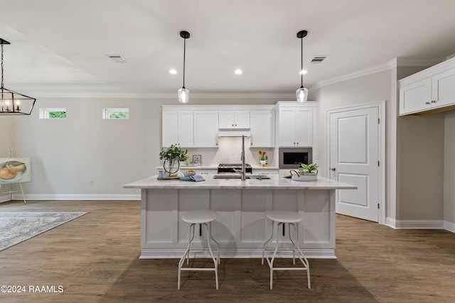 kitchen featuring hanging light fixtures, white cabinets, a kitchen island with sink, and dark hardwood / wood-style floors