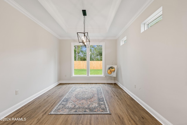 unfurnished dining area featuring a healthy amount of sunlight, hardwood / wood-style flooring, a tray ceiling, and a notable chandelier