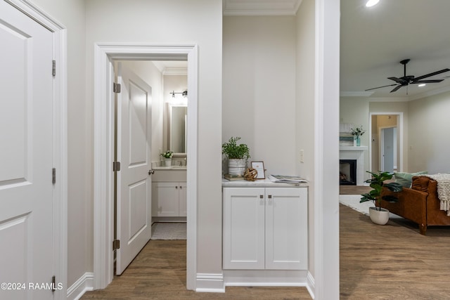 hall with dark wood-type flooring and crown molding