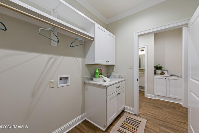 clothes washing area with cabinets, dark hardwood / wood-style flooring, crown molding, and hookup for a washing machine