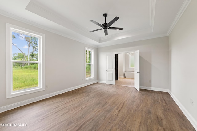 unfurnished room featuring crown molding, a tray ceiling, and hardwood / wood-style floors