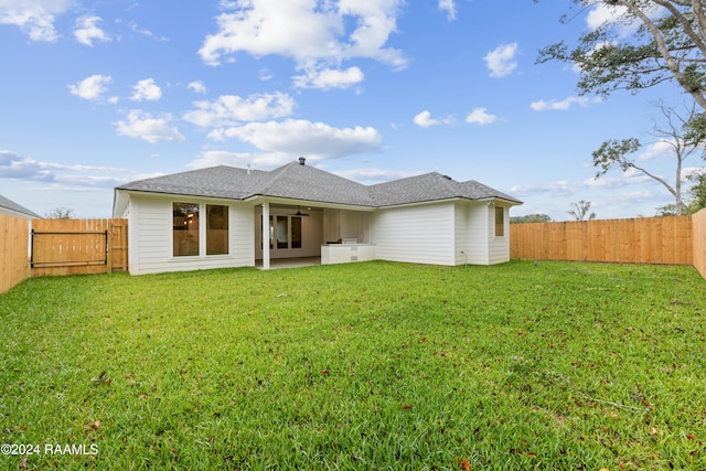 rear view of house with a patio and a yard