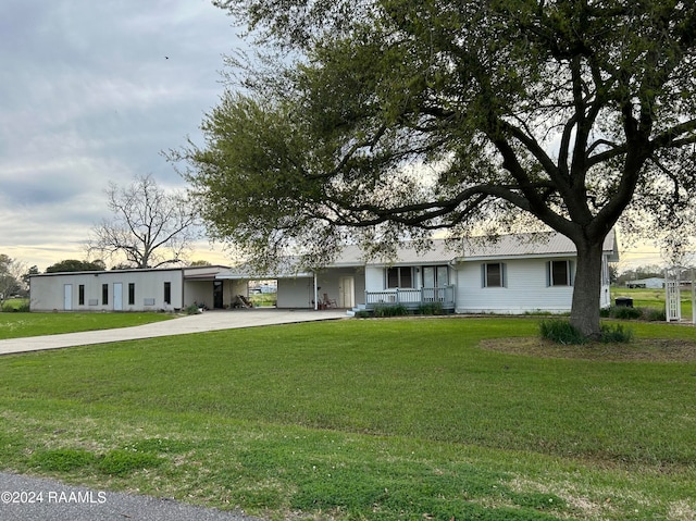 ranch-style house featuring a lawn, covered porch, and a carport