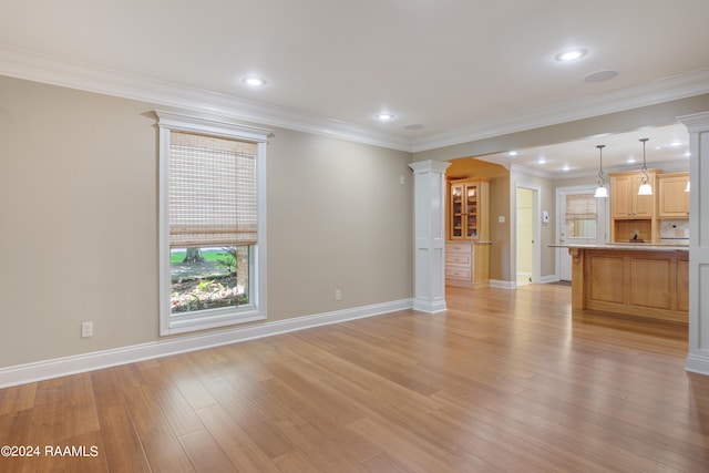 unfurnished living room featuring crown molding, decorative columns, and light wood-type flooring