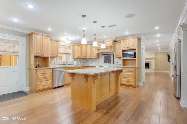 kitchen with decorative light fixtures, appliances with stainless steel finishes, backsplash, a center island, and light wood-type flooring