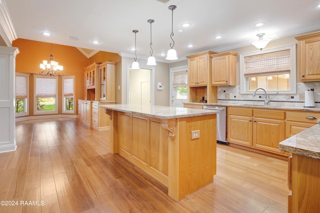 kitchen featuring a kitchen bar, tasteful backsplash, sink, a center island, and light wood-type flooring