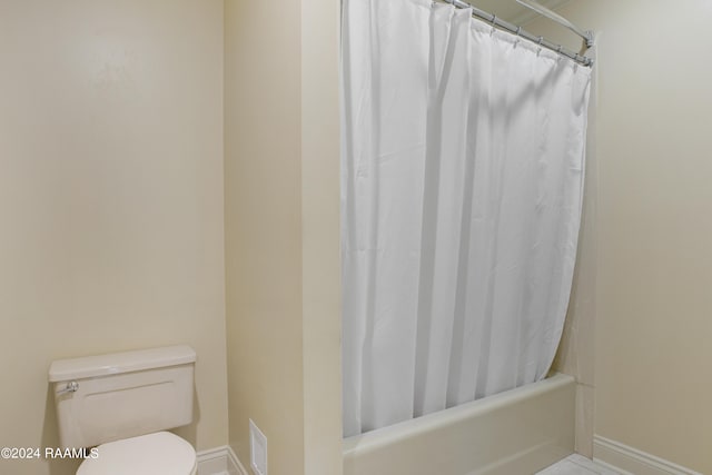 bathroom with shower / bathtub combination with curtain and toilet