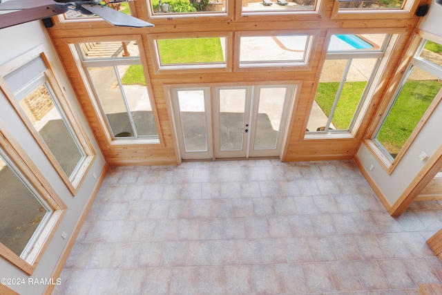 unfurnished sunroom featuring a healthy amount of sunlight and ceiling fan