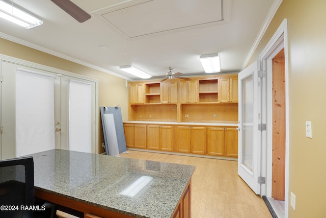 kitchen featuring crown molding, kitchen peninsula, stone countertops, light hardwood / wood-style floors, and ceiling fan