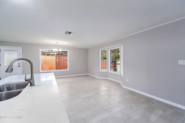 kitchen featuring sink, a notable chandelier, a textured ceiling, hanging light fixtures, and light tile flooring