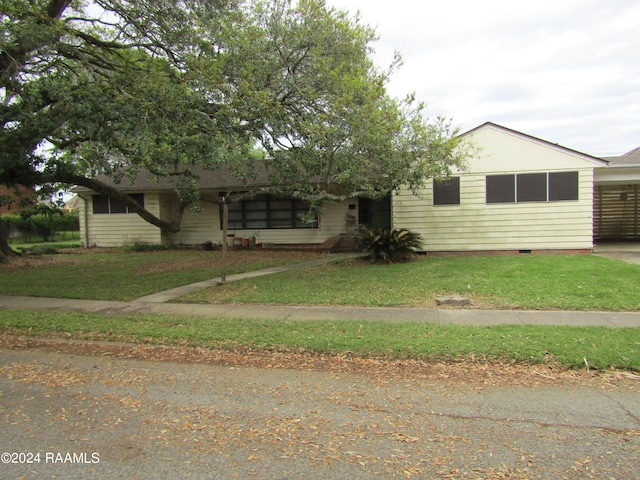 view of front facade featuring an attached carport, crawl space, and a front yard