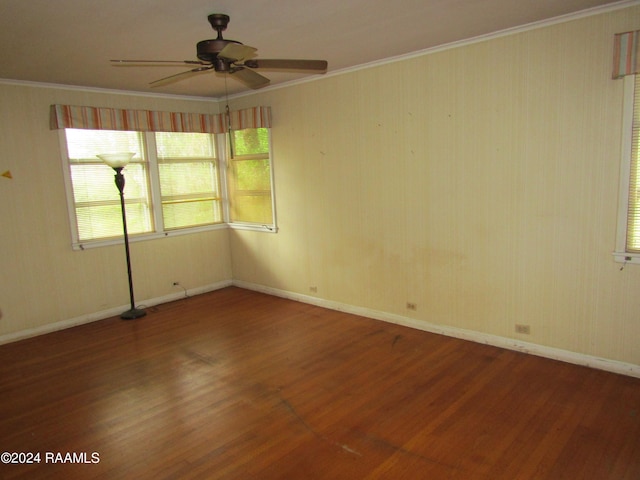 empty room featuring ceiling fan, hardwood / wood-style flooring, and crown molding