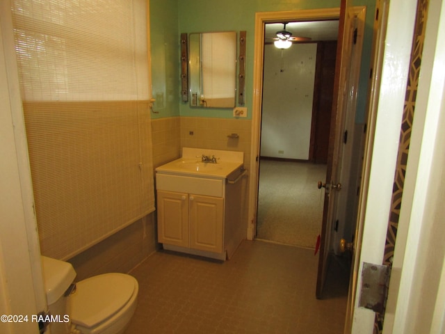 bathroom featuring ceiling fan, backsplash, tile floors, toilet, and vanity