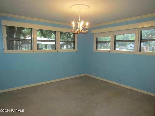 carpeted empty room featuring a notable chandelier and ornamental molding