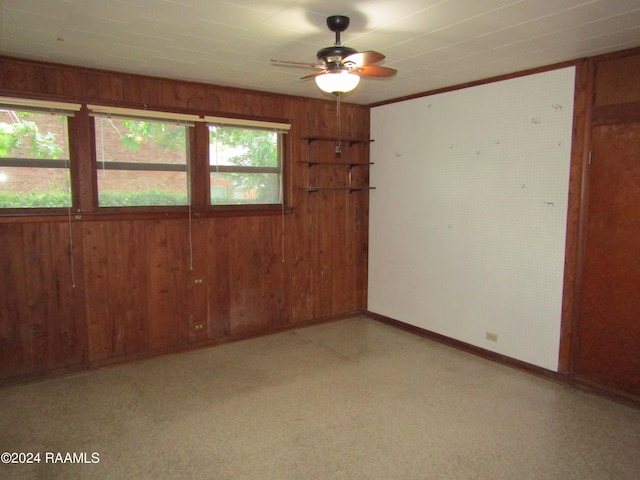 spare room with wooden walls and ceiling fan