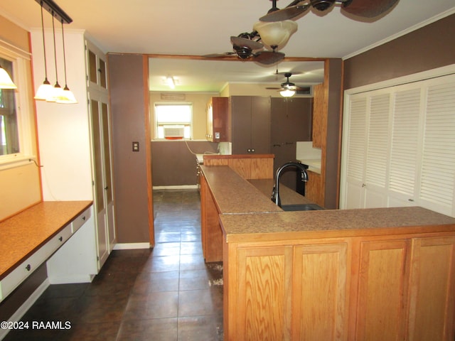 kitchen featuring ornamental molding, pendant lighting, sink, ceiling fan, and dark tile floors