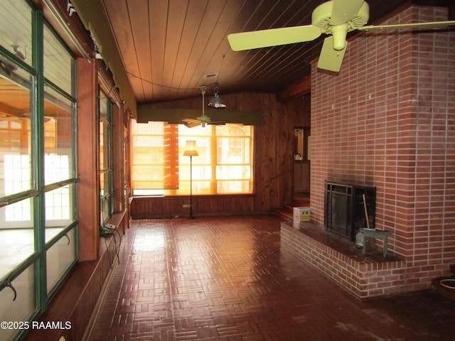 unfurnished sunroom with ceiling fan, wooden ceiling, a fireplace, visible vents, and vaulted ceiling