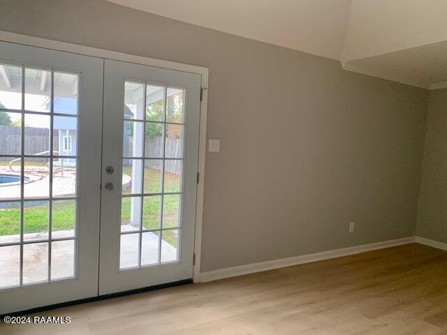 doorway to outside featuring light wood finished floors, french doors, and baseboards