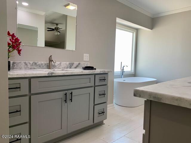 full bathroom with a freestanding bath, ceiling fan, ornamental molding, and vanity