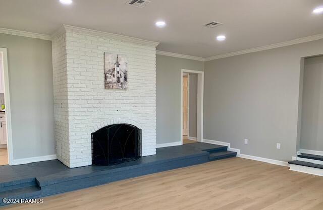 unfurnished living room with crown molding, a fireplace, visible vents, light wood-style flooring, and baseboards