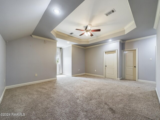 carpeted spare room featuring a raised ceiling, ornamental molding, and ceiling fan