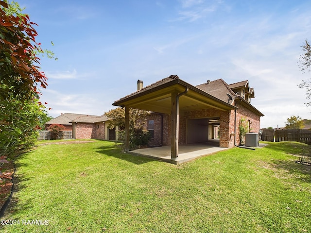 rear view of property with a yard, a patio area, and central air condition unit