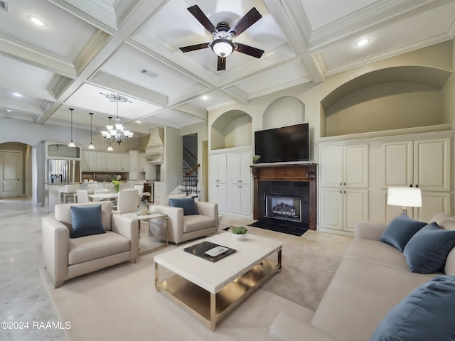 living room with beamed ceiling, ornamental molding, coffered ceiling, and ceiling fan with notable chandelier