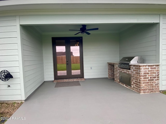 view of exterior entry featuring ceiling fan, a patio, an outdoor kitchen, and french doors