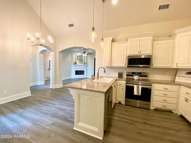 kitchen featuring sink, appliances with stainless steel finishes, dark hardwood / wood-style floors, tasteful backsplash, and kitchen peninsula