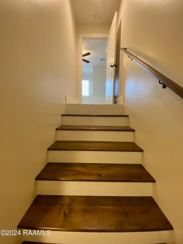 stairs featuring ceiling fan