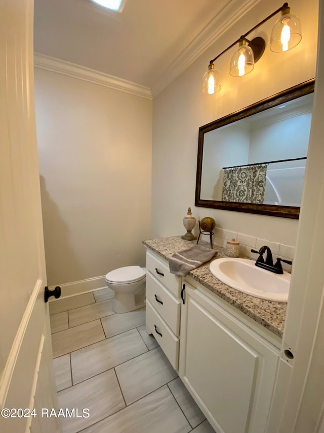 bathroom featuring ornamental molding, decorative backsplash, tile patterned flooring, vanity, and toilet