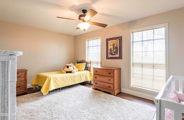 bedroom with multiple windows, a textured ceiling, and ceiling fan