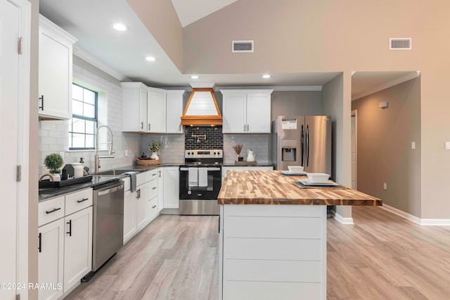 kitchen featuring a center island, light wood-type flooring, appliances with stainless steel finishes, and custom range hood