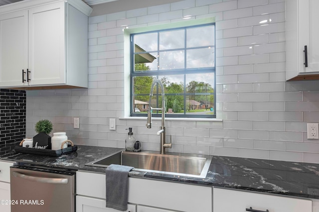 kitchen with dark stone counters, white cabinets, and dishwasher