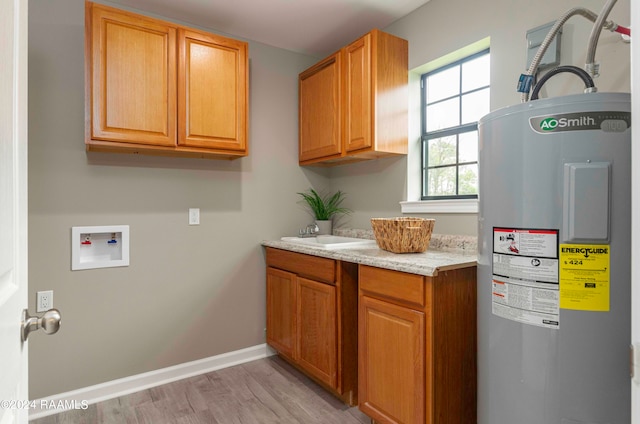 clothes washing area featuring hookup for a washing machine, cabinets, electric water heater, and light hardwood / wood-style flooring