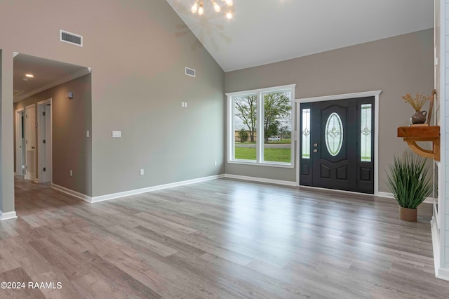 foyer entrance with high vaulted ceiling and light hardwood / wood-style floors