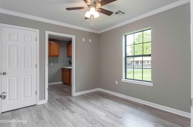 unfurnished bedroom featuring ornamental molding, light hardwood / wood-style floors, and multiple windows