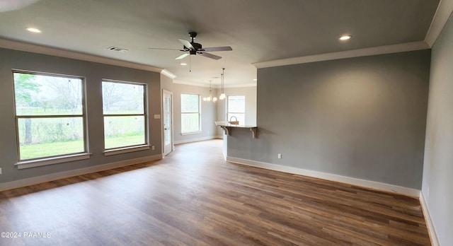 spare room with crown molding, ceiling fan with notable chandelier, and wood-type flooring