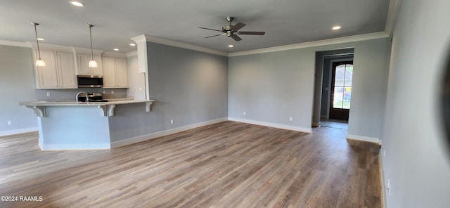 kitchen with decorative light fixtures, stainless steel appliances, a kitchen breakfast bar, kitchen peninsula, and ceiling fan