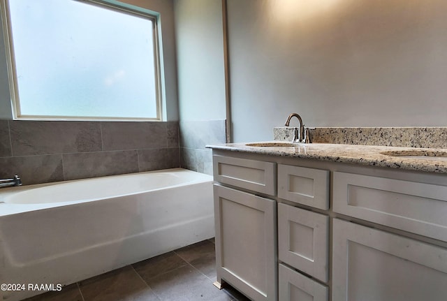 bathroom featuring tile patterned flooring, vanity, a wealth of natural light, and a bathtub