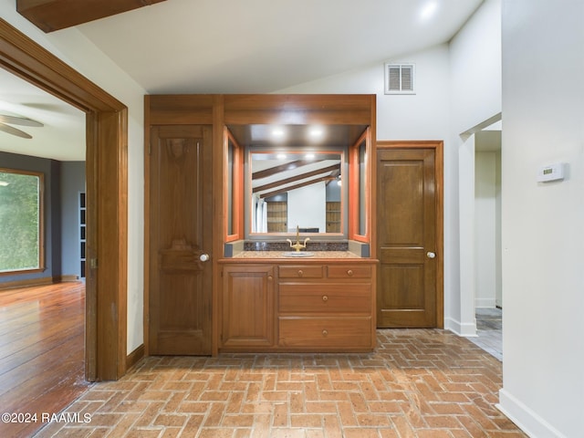 interior space with lofted ceiling with beams, ceiling fan, and vanity