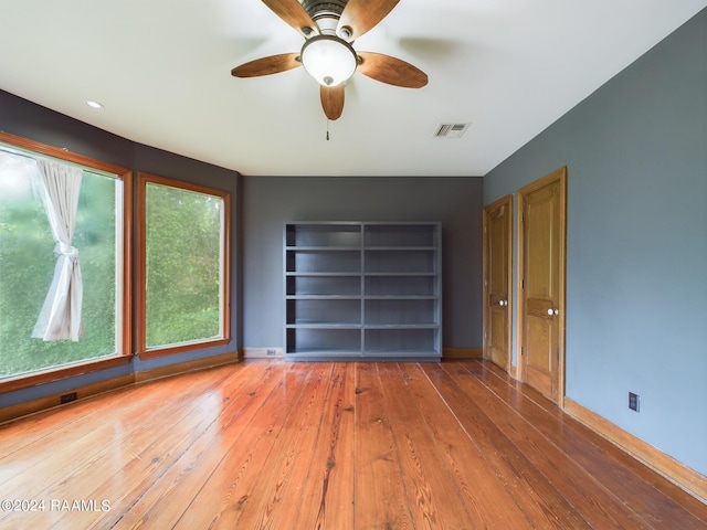 interior space featuring ceiling fan, hardwood / wood-style flooring, and built in shelves