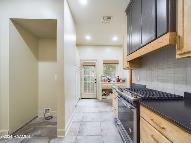 kitchen with light tile flooring, tasteful backsplash, light brown cabinets, and stainless steel gas stove