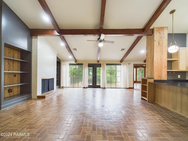 unfurnished living room with a fireplace, beam ceiling, ceiling fan, and brick wall