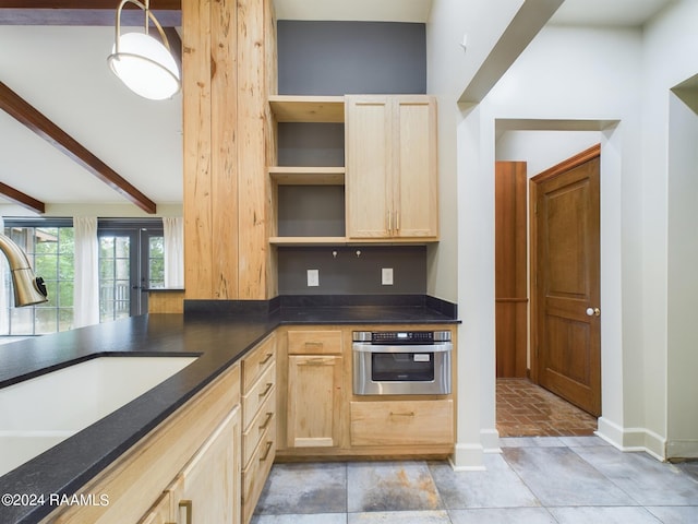 kitchen with beamed ceiling, light brown cabinetry, sink, stainless steel oven, and light tile floors