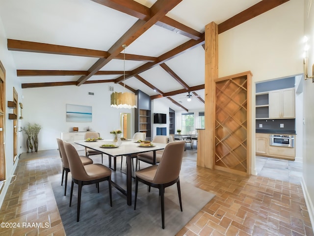 tiled dining space featuring ceiling fan, lofted ceiling with beams, and built in shelves