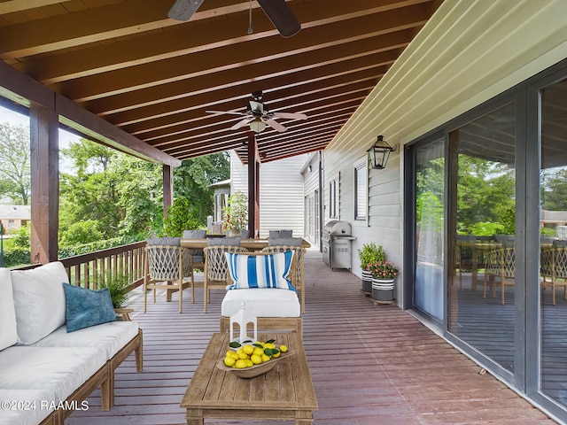 wooden terrace with an outdoor living space, ceiling fan, and area for grilling