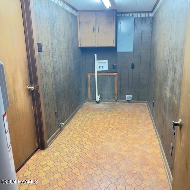 laundry room featuring cabinets, washer hookup, electric panel, and wooden walls